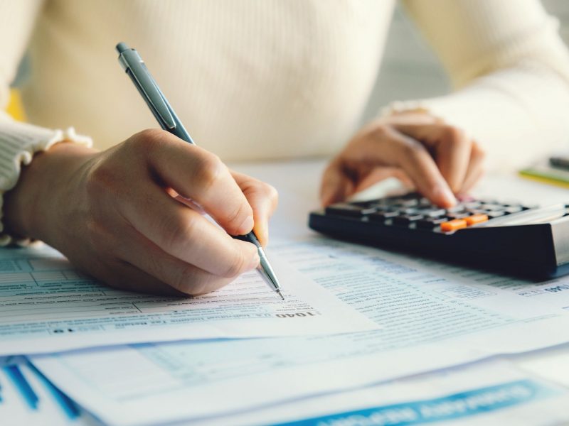 Closeup woman filling form of Individual Income Tax Return,