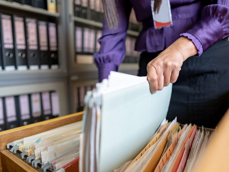 The hand of a woman holds important documents in the office.